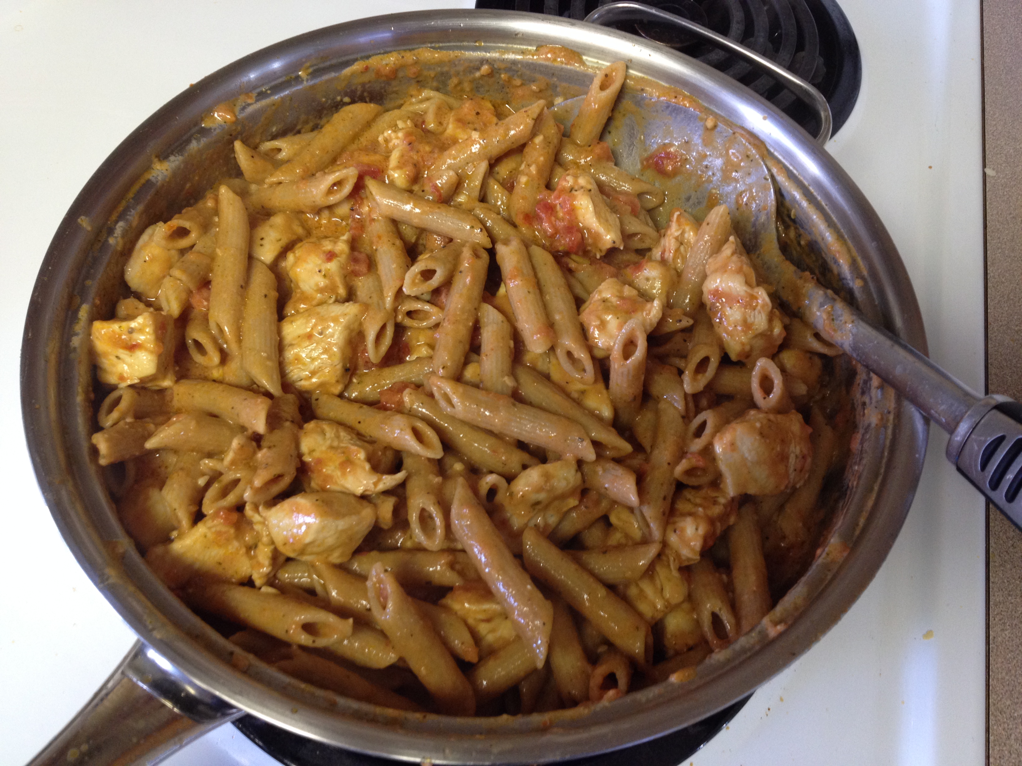 mixing in Penne pasta to make stirring to until  thickened Herbed Chicken Penne with Creamy Italian Cheese.JPG